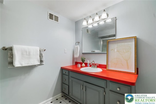 bathroom with vanity, baseboards, and tile patterned flooring