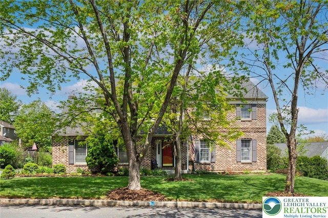 view of front of property with brick siding and a front lawn