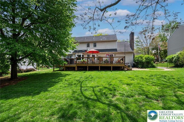 rear view of house featuring a wooden deck and a chimney