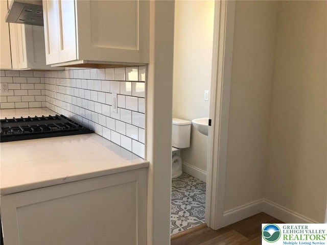 65 Island Ct, Williams Twp, PA 18042 - bathroom featuring toilet, tasteful backsplash, baseboards, and wood finished floors