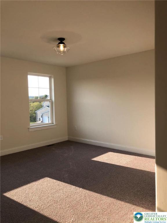 65 Island Ct, Williams Twp, PA 18042 - spare room with dark colored carpet and baseboards