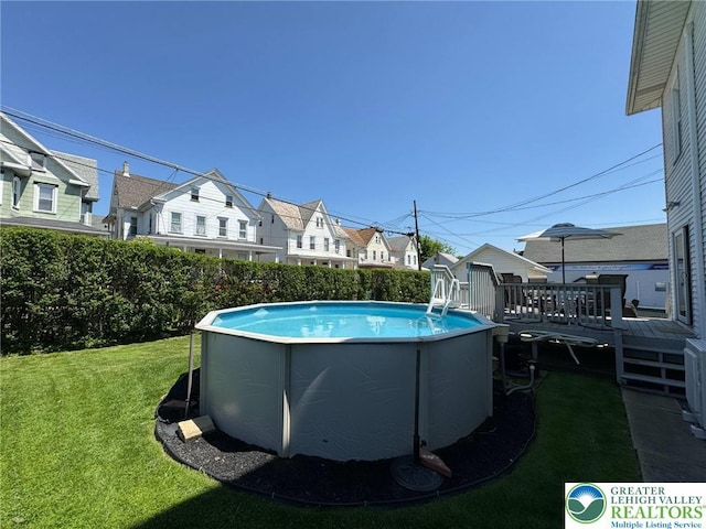 view of pool featuring a residential view, a lawn, and a wooden deck