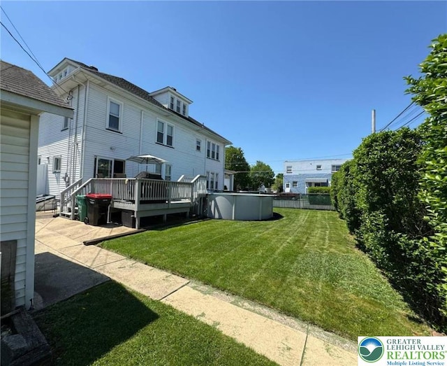 back of property with a deck and a yard