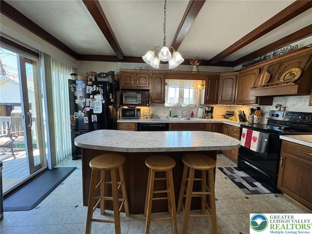 kitchen featuring black appliances, a sink, light countertops, beam ceiling, and a chandelier