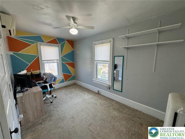 carpeted office featuring plenty of natural light, ceiling fan, a wall mounted air conditioner, and baseboards