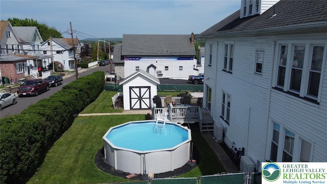 outdoor pool with a storage unit, an outdoor structure, and a deck