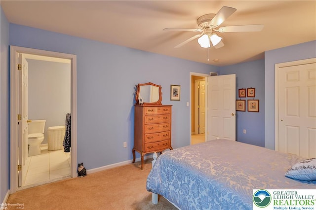 bedroom featuring light colored carpet, baseboards, ensuite bath, and ceiling fan