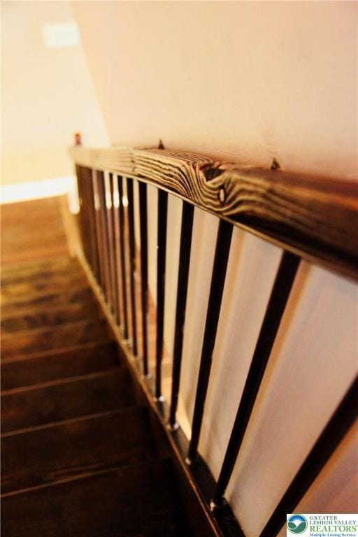 stairs featuring wood finished floors and baseboards