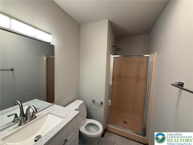 bathroom featuring a stall shower, tile patterned floors, vanity, and toilet