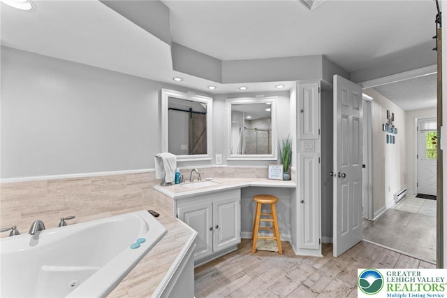 full bathroom with a whirlpool tub, vanity, a baseboard radiator, recessed lighting, and wood finished floors