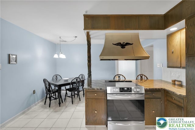 kitchen with electric range, exhaust hood, a chandelier, baseboards, and backsplash