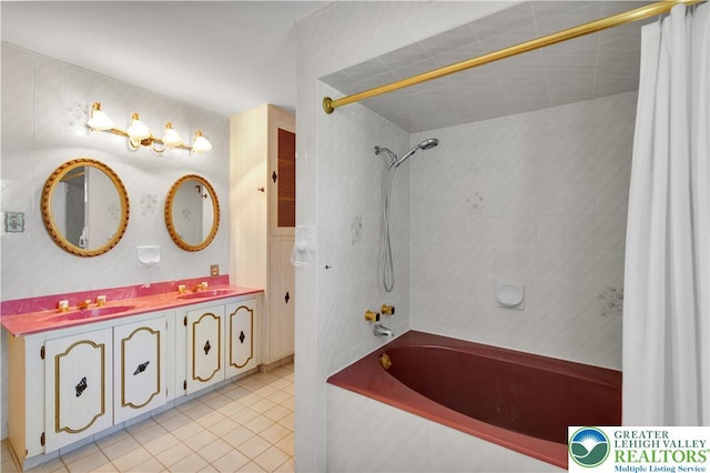 full bathroom with tile patterned floors, tiled shower / bath combo, double vanity, and tile walls