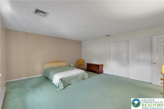 carpeted bedroom with a closet and baseboards
