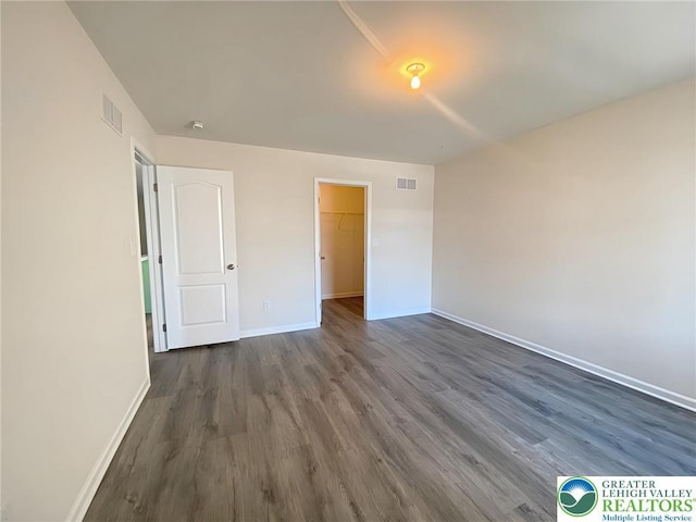 306 Redclover Ln, Upper Macungie Twp, PA 18104 - unfurnished bedroom with baseboards, dark wood-style floors, a spacious closet, and a closet