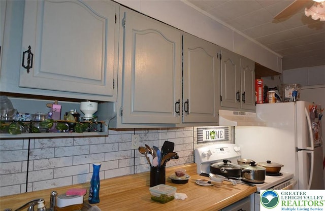 kitchen featuring under cabinet range hood, white electric stove, backsplash, light countertops, and gray cabinets