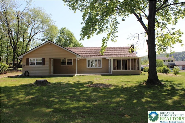 back of property featuring a sunroom and a yard