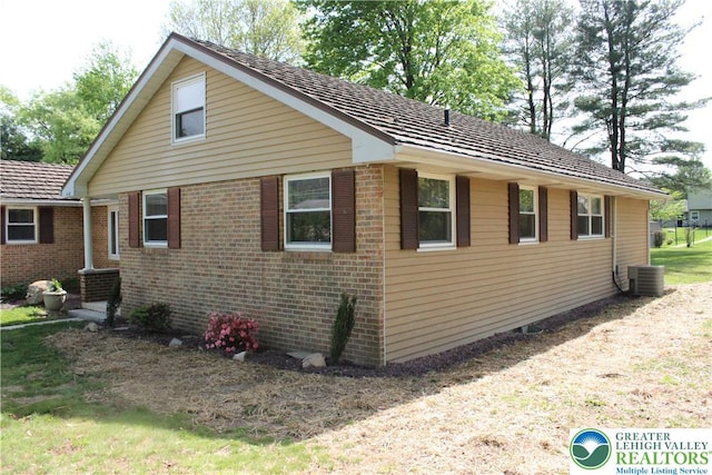 view of home's exterior featuring central AC and brick siding
