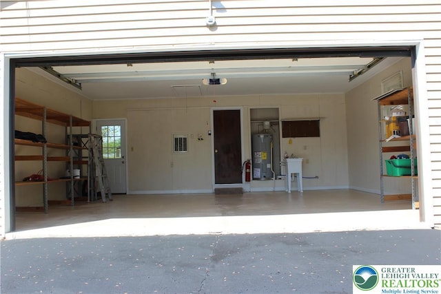 garage with electric water heater, a garage door opener, and asphalt driveway
