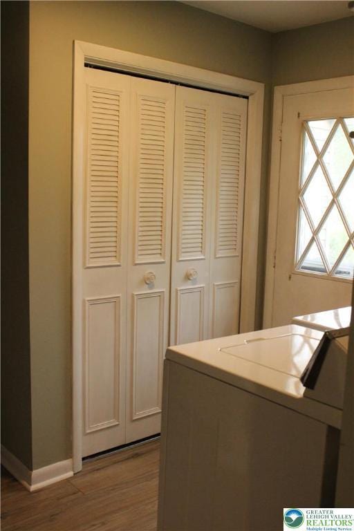 laundry room featuring washer and dryer, wood finished floors, and baseboards