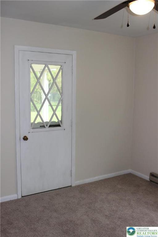carpeted empty room with ceiling fan and baseboards
