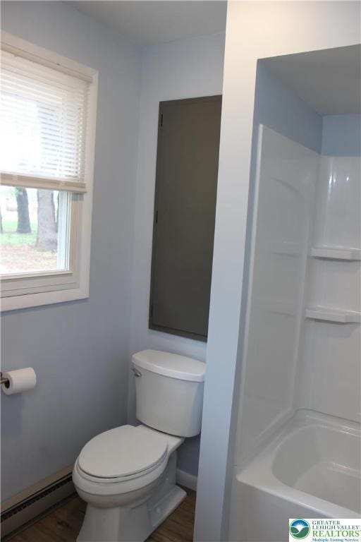 full bathroom with baseboard heating, toilet, baseboards,  shower combination, and wood finished floors