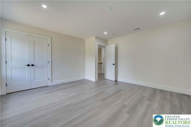 unfurnished bedroom featuring light wood finished floors, recessed lighting, baseboards, and a closet