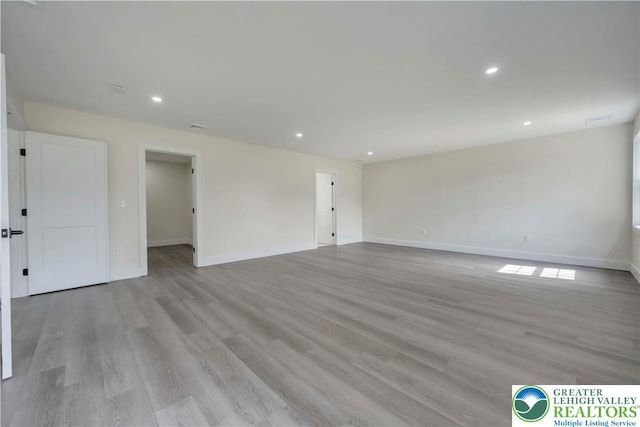 unfurnished room with baseboards, light wood-style flooring, and recessed lighting