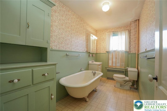 415 Hazle St, Tamaqua Borough, PA 18252 - full bathroom featuring radiator heating unit, wallpapered walls, wainscoting, toilet, and a freestanding tub