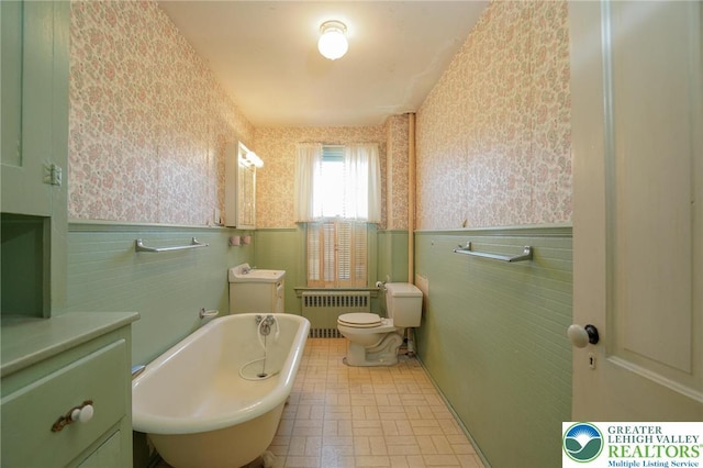 415 Hazle St, Tamaqua Borough, PA 18252 - bathroom featuring radiator, wallpapered walls, tile walls, wainscoting, and a soaking tub