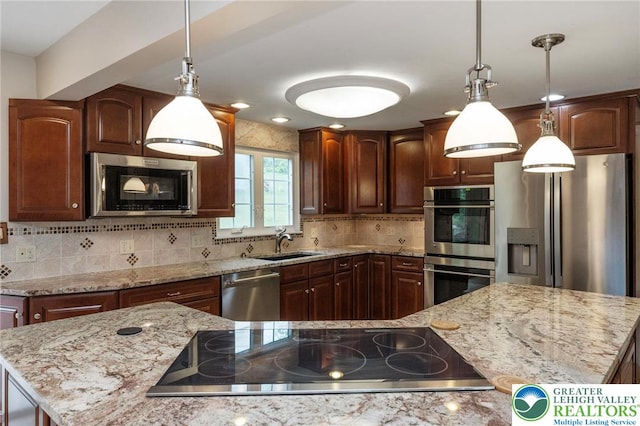 kitchen featuring appliances with stainless steel finishes, a sink, backsplash, light stone countertops, and hanging light fixtures