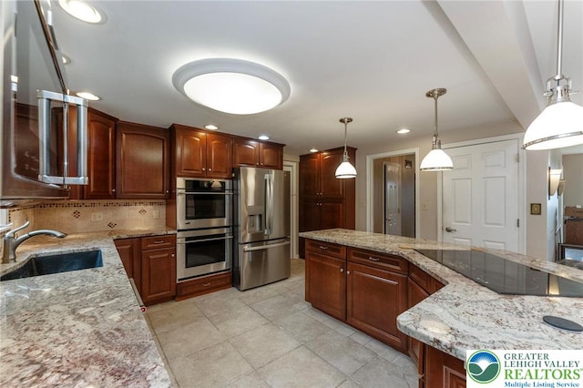 kitchen with appliances with stainless steel finishes, a sink, decorative backsplash, light stone countertops, and pendant lighting