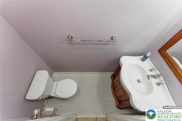 bathroom featuring toilet, a sink, and tile patterned flooring