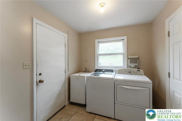 laundry room featuring separate washer and dryer and light tile patterned flooring