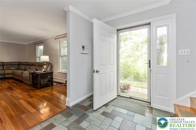 foyer featuring baseboard heating, crown molding, healthy amount of natural light, baseboards, and stone tile floors