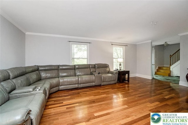 living area featuring ornamental molding, light wood-style floors, stairs, and baseboards
