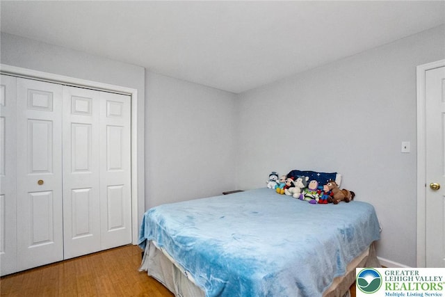 bedroom with light wood finished floors and a closet