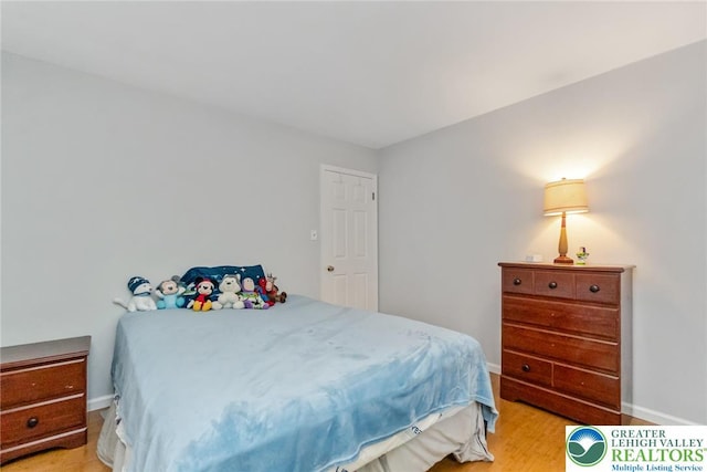bedroom featuring light wood-style floors and baseboards