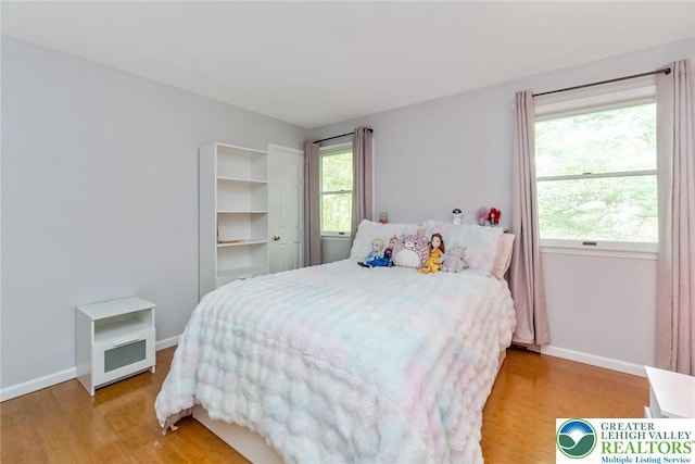 bedroom featuring light wood-style floors and baseboards