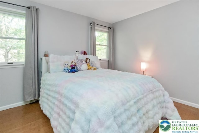 bedroom featuring baseboards and wood finished floors