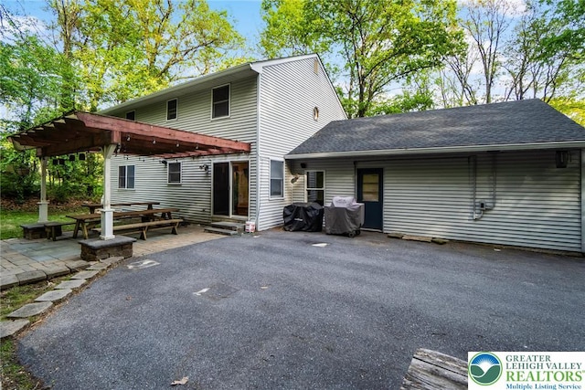 rear view of property with a patio, a pergola, roof with shingles, and entry steps