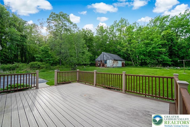 wooden deck featuring a yard, an outbuilding, and a barn