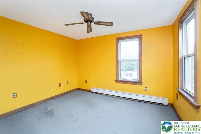 empty room with baseboard heating, carpet, and healthy amount of natural light