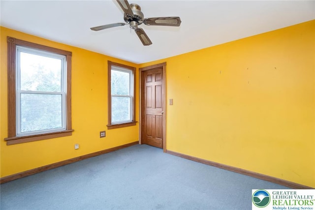 empty room with baseboards, light carpet, and a ceiling fan
