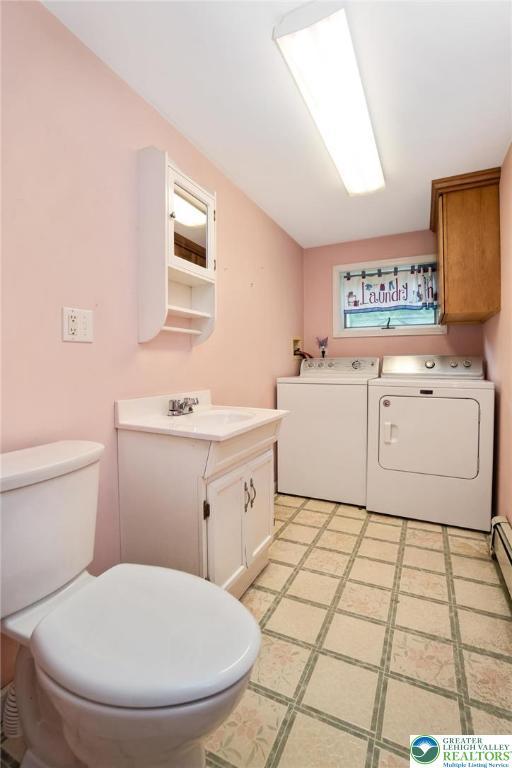 bathroom featuring washer and clothes dryer, toilet, and vanity