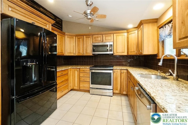 kitchen featuring appliances with stainless steel finishes, lofted ceiling, a sink, ceiling fan, and decorative backsplash