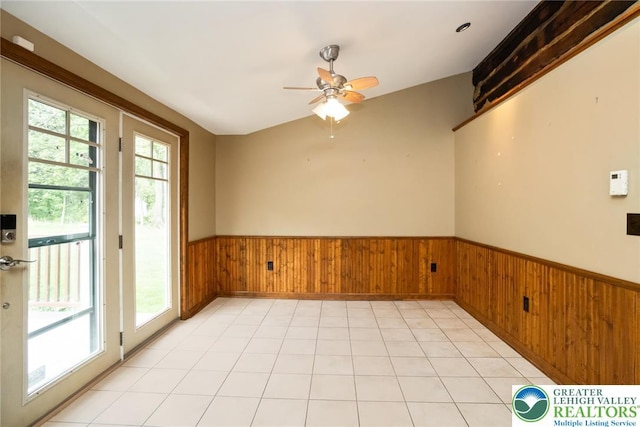 spare room featuring a wainscoted wall, a ceiling fan, and wooden walls