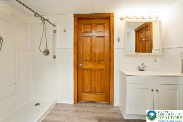 bathroom with a shower, wood finished floors, and vanity