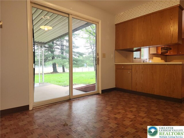 doorway to outside with baseboards and a sink