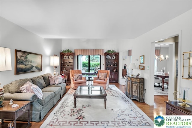 living room with a chandelier and wood finished floors
