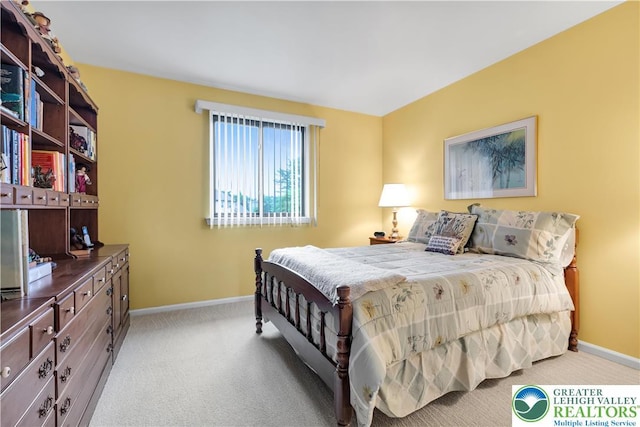 bedroom with baseboards and light colored carpet